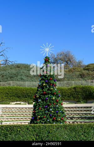 Der geschmückte Weihnachtsbaum steht tagsüber unter blauem Himmel im Freien Stockfoto