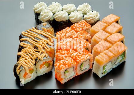 Ein Set aus köstlichem und saftigem Sushi auf einem schwarzen Ständer Stockfoto