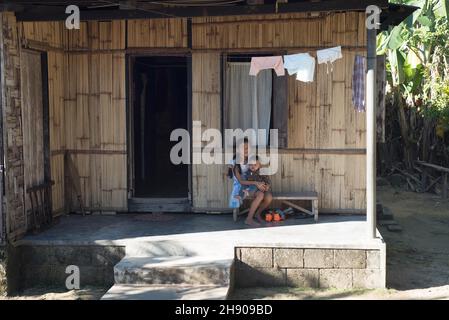 Zwei Kinder sitzen vor einem Khasi-Haus im Dorf Mawlynong, Bezirk East Khasi Hills, Meghalaya, Indien Stockfoto