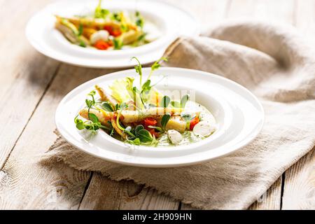 Gourmet-Fischsalat. Pangasius-Dori-Filet, Gemüse, Avocado-Pastete, Mozzarella und frische Kräuter. Restaurant serviert. Das Gericht des Küchenchefs. Gesund und lecker fo Stockfoto