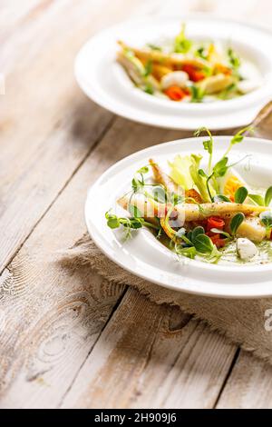 Gourmet-Fischsalat aus nächster Nähe. Pangasius-Dori-Filet, Gemüse, Avocado-Pastete, Mozzarella und frische Kräuter. Restaurant serviert. Gesundes und leckeres Essen o Stockfoto