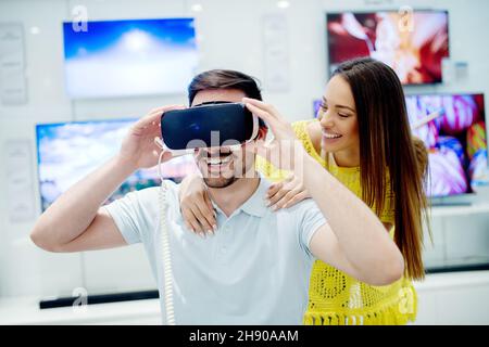 Glückliches Paar versucht auf 3D Virtual-Reality-Brille. Spaß beim Ausprobieren neuer Technologien. Stockfoto