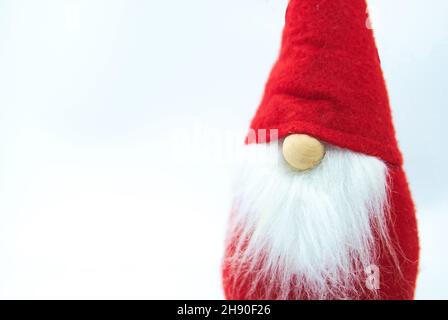 Skandinavischer Gnome in Red hat für Winterurlaub Postkarte mit Platz für Grußtext. Nahaufnahme des niedlichen Weihnachtsdwerfs auf weißem Hintergrund. Stockfoto
