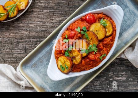 Reisjollof mit frittiertem Kochbananen - würziges vegetarisches afrikanisches Reisgericht Stockfoto