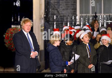 London, Großbritannien. 1st. Dezember 2021 - Boris Johnson PM schaltet die Weihnachtsbeleuchtung in der Downing Street ein, nachdem er einem Kinderchor bei der Weihnachtslieder zugehört hat Stockfoto