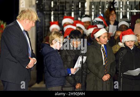 London, Großbritannien. 1st. Dezember 2021 - Boris Johnson PM schaltet die Weihnachtsbeleuchtung in der Downing Street ein, nachdem er einem Kinderchor bei der Weihnachtslieder zugehört hat Stockfoto