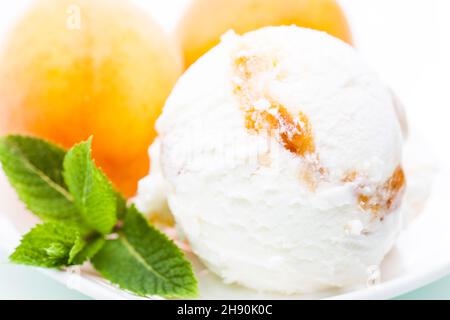Joghurt - Aprikosen-Eislöffel mit Aprikosen- und Minzblättern Stockfoto