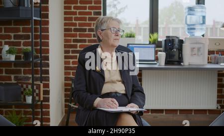 Psychiater warten auf Menschen, die an einer Gruppentherapie im Weltraum teilnehmen, mit einem Schild für ein Treffen an Bord. Frau Therapeutin hält Zwischenablage und Vorbereitung für die Rehabilitation und Beratung Sitzung. Stockfoto