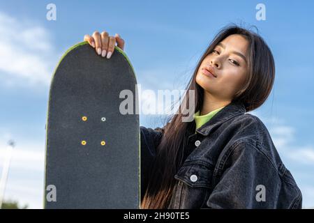 Stylische coole Teenager Skateboarderin im Skatepark.