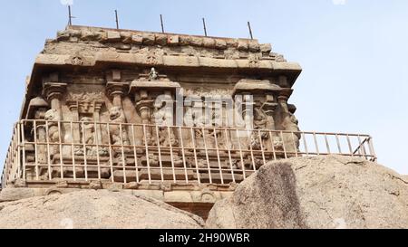 Mahabalipuram Olakkanneshvara Temple Stein geschnitzte Idole an der Wand. Die Felswand befindet sich im Hintergrund. Stockfoto