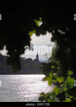 Vertikale Aufnahme der von Bäumen umgebenen Seekirche Stockfoto