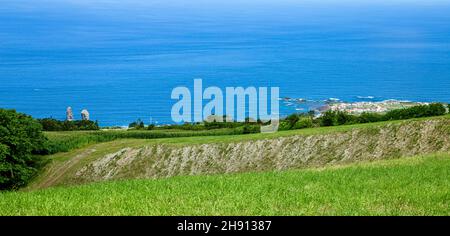 Vulkangestein Ilhéus dos Mosteiros, São Miguel, Azoren, Açores, Portugal, Europa. Ilhéus dos Mosteiros auf der linken Seite, die Stadt Mosteiros auf der Stockfoto