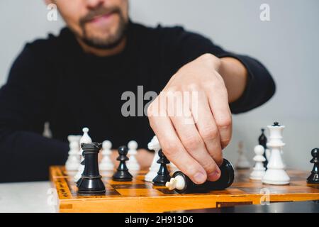 Mann mit Bart spielt Schach an Bord. Strategie- und Wettbewerbskonzept. Selektiver Fokus Stockfoto