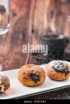 Bombolon oder Bomboloni ist ein italienisches gefülltes Donut- und Snackfutter. Deutsche Krapfen - Krapfen oder berliner - gefüllt mit Marmelade und Schokolade Stockfoto