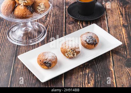 Bombolon oder Bomboloni ist ein italienisches gefülltes Donut- und Snackfutter. Deutsche Krapfen - Krapfen oder berliner - gefüllt mit Marmelade und Schokolade Stockfoto