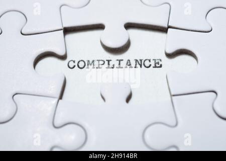 Das Wort Compliance mit einer Schreibmaschine geschrieben. Stockfoto