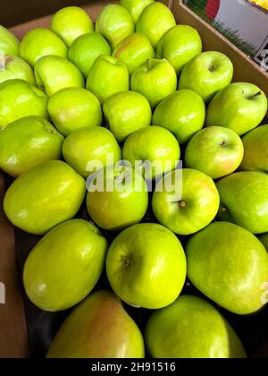 Grüne Äpfel in einer Pappschachtel auf dem Markt. Stockfoto