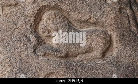 Löwenskulptur in Stein gemeißelt. Der Felsen befindet sich im Hintergrund Stockfoto