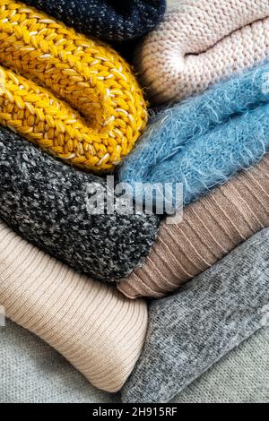 Stapel von Kleidung mit verschiedenen Farben und Materialien. Stockfoto