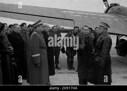 Warszawa, 1947-03-29. Sprowadzenie cia³a gen. Karola Œwierczewskiego. NZ. po wyl¹dowaniu samolotu na lotnisku Okêcie dowódca Warszawskiego Okrêgu Wojskowego gen. Gustaw Paszkiewicz (P) sk³ada raport. W Centrum: marsza³ek Micha³ Rola-¯ymierski, W³adys³aw Gomu³ka; od lewej: Siostra gen. Œwierczewskiego, Hilary Minc, Stanis³aw Radkiewicz. bb/gr PAP Warschau, 29. März 1947. Die Leiche von General Karol Swierczewski wird nach Warschau gebracht. Im Bild: Nach der Generalsanierung des Warschauer Militärbezirks General Gustaw Paszkiewicz (von rechts). Im Zentrum Marschall Michal Rola-Zymierski, Stockfoto