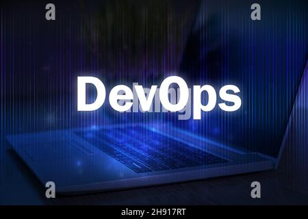 DevOps-Text auf blauem Technologiehintergrund mit Laptop. DevOps kombiniert Softwareentwicklung und IT-Betrieb. Stockfoto