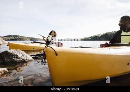 Frau im Gespräch mit Freund während Kajak auf See Stockfoto