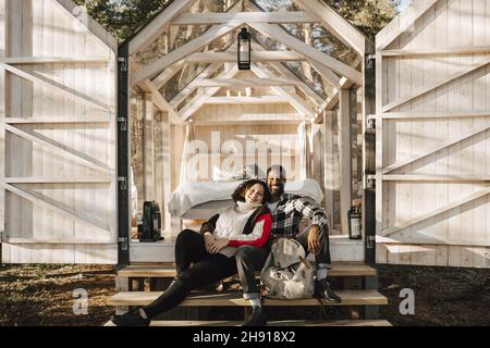 Porträt eines lächelnden Paares, das auf der Hüttentreppe sitzt Stockfoto