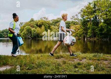 Volle Seitenansicht der männlichen und weiblichen Freiwilligen Reinigung Park Stockfoto