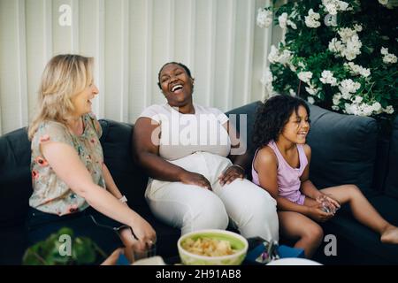 Fröhliche Mütter lachen während der Party im Hinterhof Stockfoto