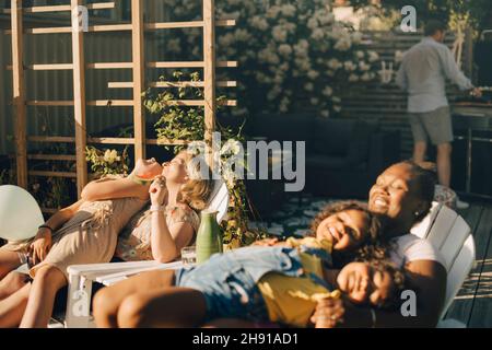 Mütter verbringen Freizeit mit Töchtern im Hinterhof während der Party Stockfoto