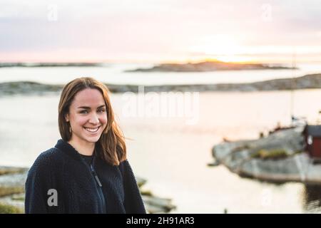 Porträt einer lächelnden Frau im Urlaub gegen das Meer Stockfoto