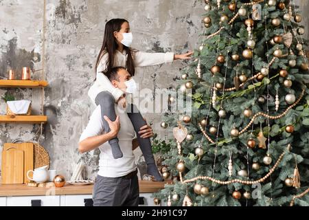 Menschen mit Geschenken, die Gesichtsmasken während des Coronavirus- und Grippeausbruchs an Weihnachten tragen. Schutz vor Viren und Krankheiten, Quarantäne zu Hause. COVID-2019. Stockfoto