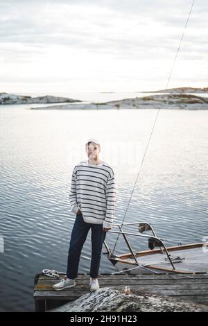 Porträt eines Mannes, der mit der Hand in der Tasche gegen das Meer steht Stockfoto