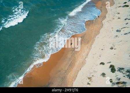 Luftaufnahme der Küste und der abstürzenden Wellen. Wunderschöner Sandstrand und tolles türkisfarbenes tropisches Meerwasser. Perfekte Sommerlandschaft. Stockfoto