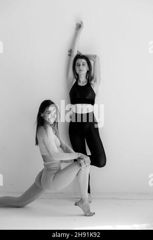Zwei Sportmädchen posieren isoliert auf weißem Hintergrund. Fitness-Modell Frau im Studio mit Kopierer Platz Stockfoto