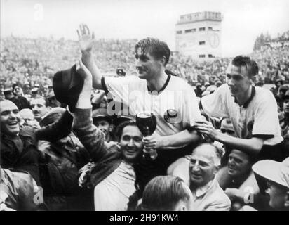 ABGELEGT - 04. Juli 1954, Schweiz, Bern: Der deutsche Stürmer und Kapitän Fritz Walter (M, oben) und sein lauter-Teamkollege Horst Eckel (r) werden nach ihrem Triumph im Weltcup-Finale im Berner Wankdorf-Stadion von begeisterten Anhängern vom Feld getragen. Fritz Walter hält die Trophäe Jules Rimet, die er mit seinem Team gewonnen hat. Die deutsche Fußballnationalmannschaft besiegt Ungarn 3:2 vor 56.000 Zuschauern, darunter 5000 Deutsche, und sichert sich erstmals den Weltmeistertitel. Der ehemalige Fußball-Weltmeister Horst Eckel ist tot. Wie der Deutsche Fußball-Verband auf F bekannt gab Stockfoto