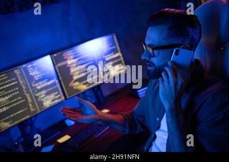 Profil Porträt von professionellen Mitarbeiter saß Tell Telefon arbeiten am Projekt spät am Abend Loft-Raum Stockfoto