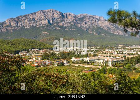 Blick auf die Stadt in einem wunderschönen Bergtal (Kemer, Türkei) mit dem Berg Tahtali (Lykischer Olymp) in der Ferne Stockfoto