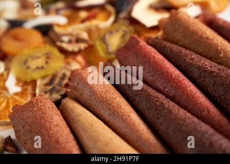 Nahaufnahme von köstlichen saftigen Früchten und Beeren Raute auf getrockneten Früchten Orange, Kiwi, Kokosnuss, Nüsse Hintergrund. Konzept der gesunden Auswahl von getrockneten Früchten für Snacks. Stockfoto