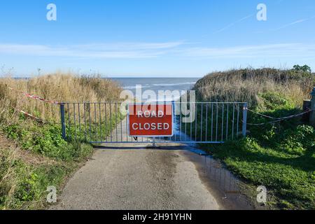 Die Straße ist an der zurückgehenden Küste in Norfolk, Großbritannien, gesperrt Stockfoto