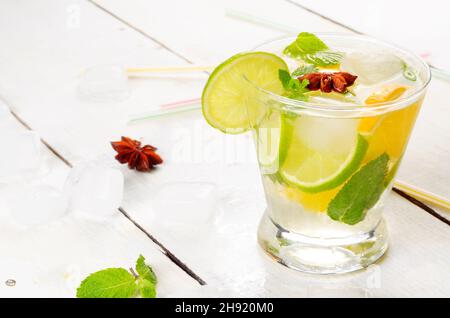 Limetten- und Orangenfrucht-Wasser mit Eis und Minze auf weißem Tisch Stockfoto