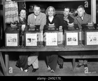 Venice Pier Fun House Party veranstaltet von CAROLE LOMBARD zu Ehren des A.C. Blumenthal und William Rhinelander Stewart im August 1935 mit Mr und Mrs CLIVE BROOK CAROLE LOMBARD WARNER BAXTER und Produzent WALTER WANGER, die von alten Peep Show Machines posiert Stockfoto