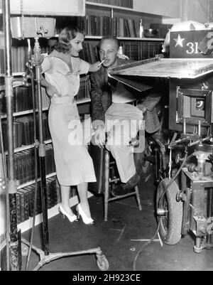 CAROLE LOMBARD und Regisseur MITCHELL LEISEN am Set offen während der Dreharbeiten von HÄNDEN ÜBER DEN TISCH 1935 Regisseur MITCHELL LEISEN Geschichte Vina Delmar Kameramann Ted Tetzlaff Kleidung für Miss Lombard entworfen von Travis Banton Paramount Picters Stockfoto