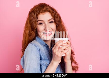 Foto von liebenswert süß junge Dame gekleidet Jeans Hemd zeigt Zunge trinken Joghurt lächelnd isoliert rosa Farbe Hintergrund Stockfoto