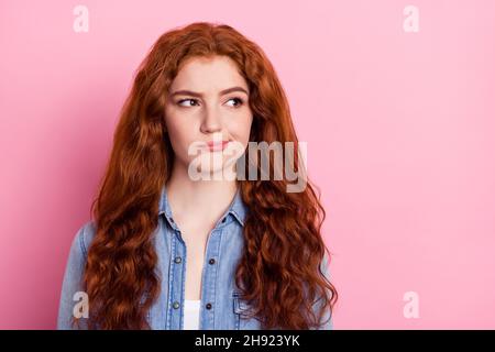 Foto von jungen hübschen Mädchen denken grübelgesinnten Blick leeren Raum isoliert über rosa Farbe Hintergrund Stockfoto