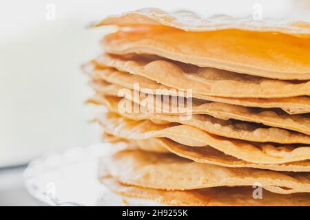 Gebackene Krümel Kuchen aus Blätterteig für Schichtkuchen auf einem Glasständer. Halbzeug für Kuchen. Nahaufnahme, selektiver Fokus, geringe Tiefe von Stockfoto