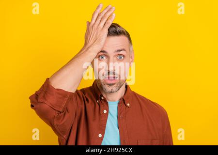 Foto von beeindruckt reifen grauen Frisur Mann Palm Gesicht tragen Kleidung isoliert auf gelbem Hintergrund Stockfoto