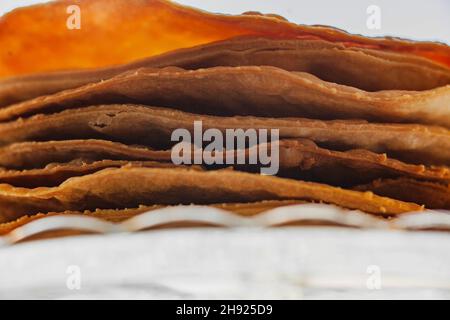 Gebackene Krümel Kuchen aus Blätterteig für Schichtkuchen auf einem Glasständer. Halbzeug für Kuchen. Nahaufnahme, selektiver Fokus, geringe Tiefe von Stockfoto