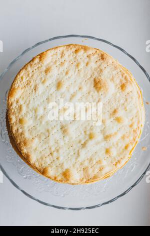 Gebackene Krümel Kuchen aus Blätterteig für die Schicht Kuchen auf einem Glasständer auf Fensterbank. Halbzeug für Kuchen. Nahaufnahme von oben Stockfoto