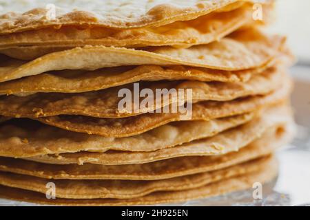 Schichten von gebackenen Krümel Kuchen aus Blätterteig für Kuchen. Halbzeug für Kuchen. Nahaufnahme, selektiver Fokus, geringe Schärfentiefe Stockfoto